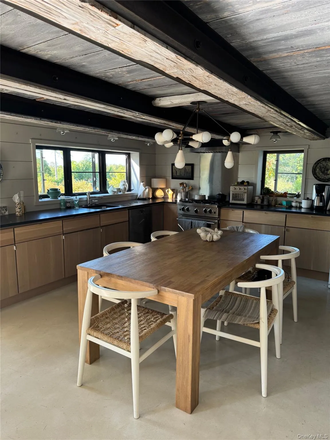Dining room with finished concrete floors and a wooden ceiling with exposed beams Dining room with finished concrete floors and a wooden ceiling with exposed beams