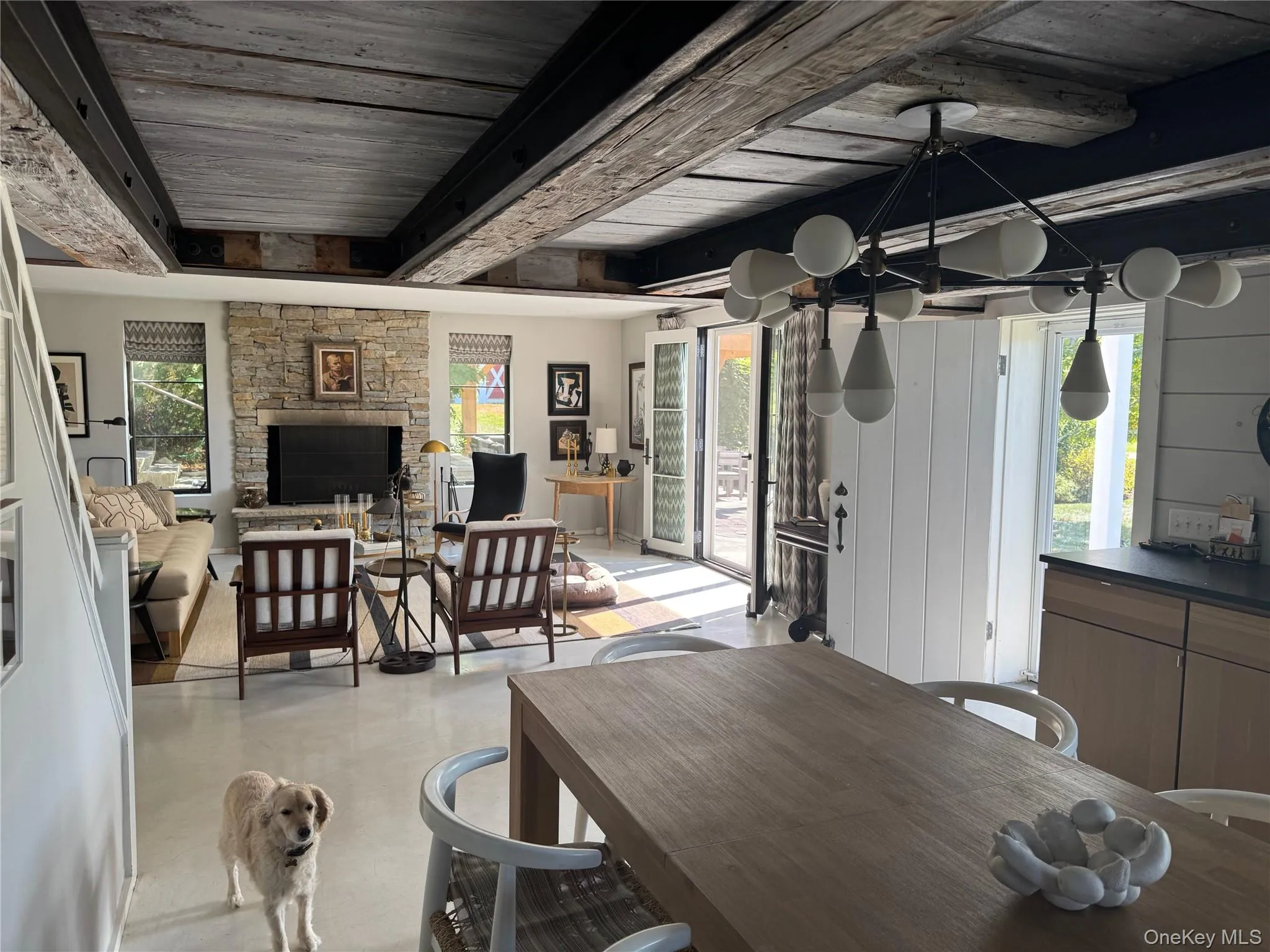 Dining space featuring a stone fireplace and a wood ceiling with exposed beams Dining space featuring a stone fireplace and a wood ceiling with exposed beams