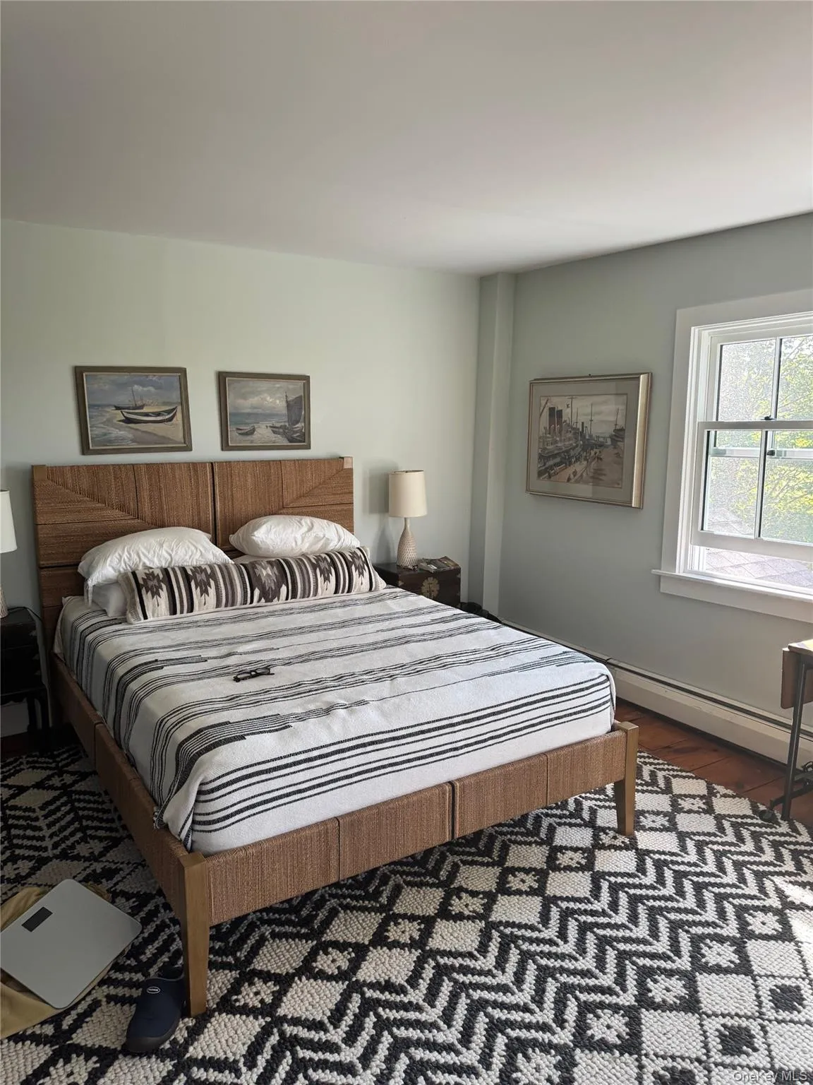 Bedroom with dark wood finished floors and a baseboard heating unit Bedroom with dark wood finished floors and a baseboard heating unit