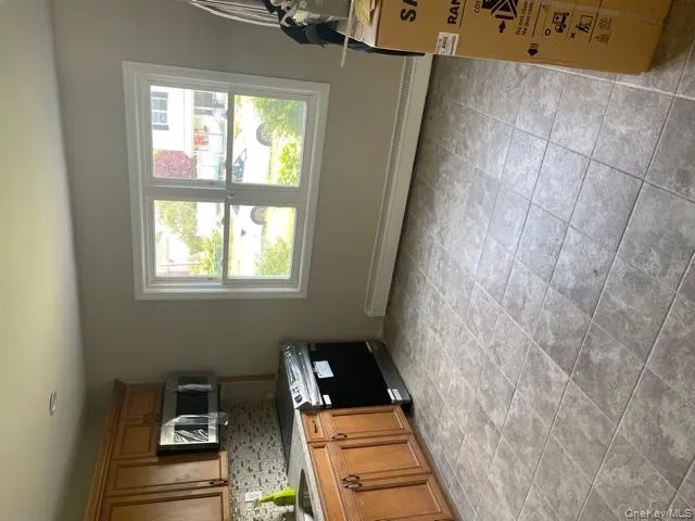 Kitchen with decorative backsplash, stove, plenty of natural light, and baseboard heating Kitchen with decorative backsplash, stove, plenty of natural light, and baseboard heating