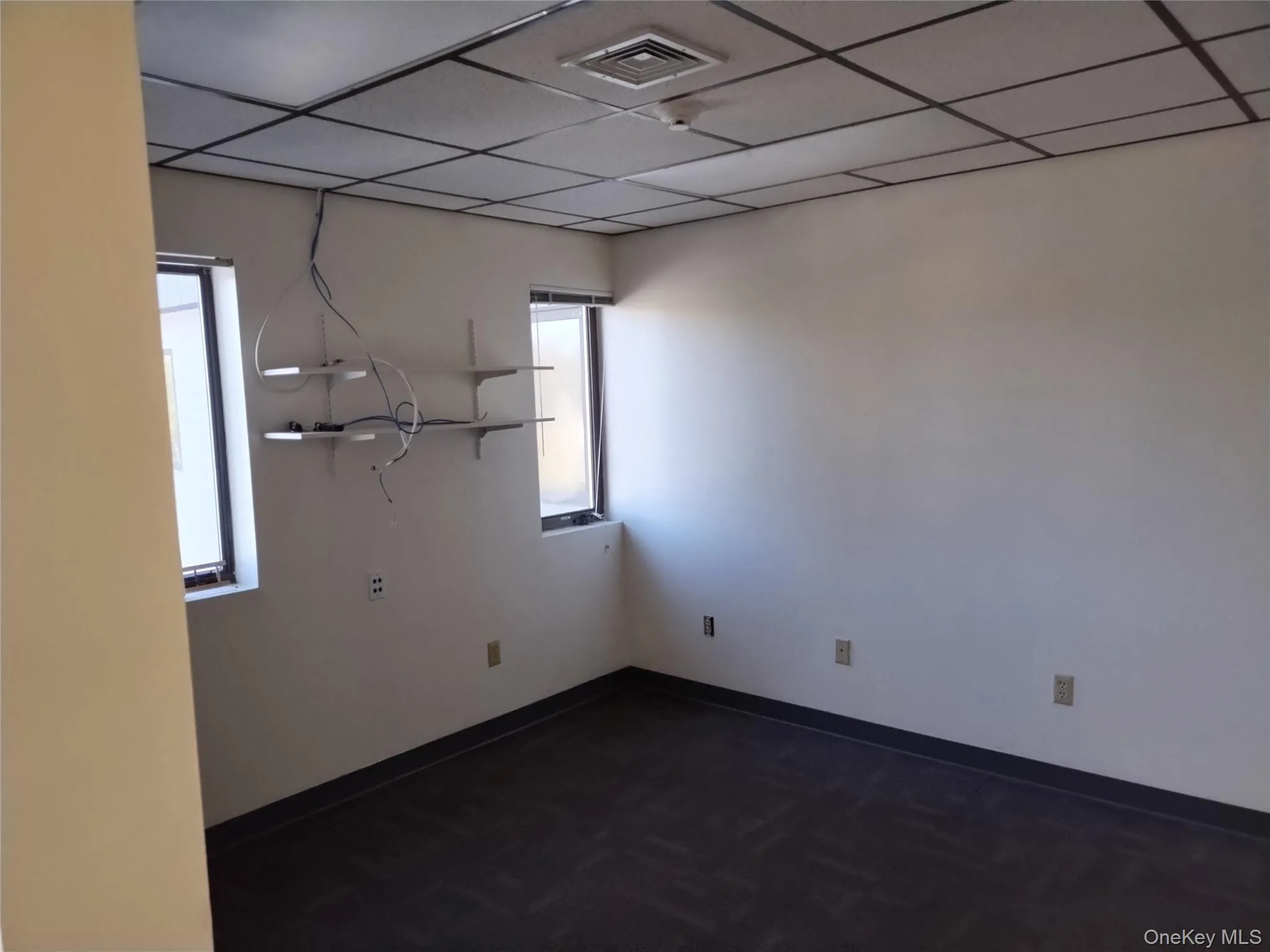 Empty room with baseboards and a drop ceiling Empty room with baseboards and a drop ceiling