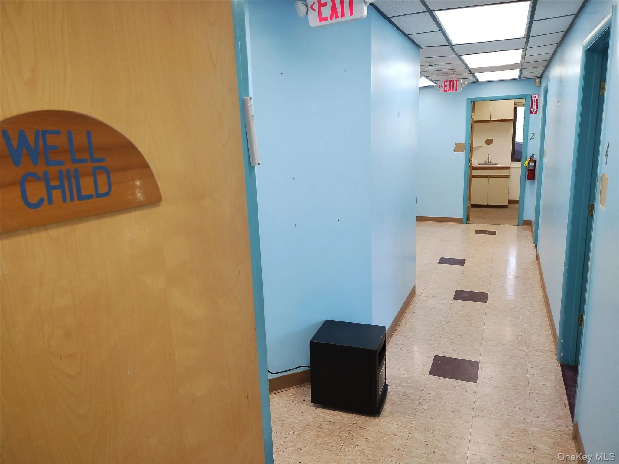 Hallway featuring a drop ceiling and light flooring Hallway featuring a drop ceiling and light flooring