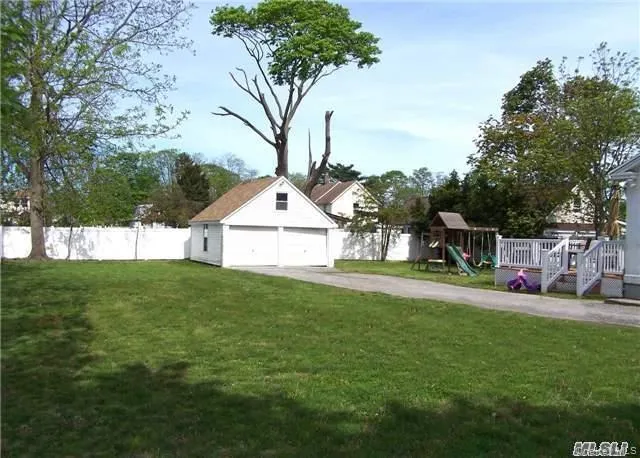 View of yard featuring a playground, a garage, and an outdoor structure View of yard featuring a playground, a garage, and an outdoor structure