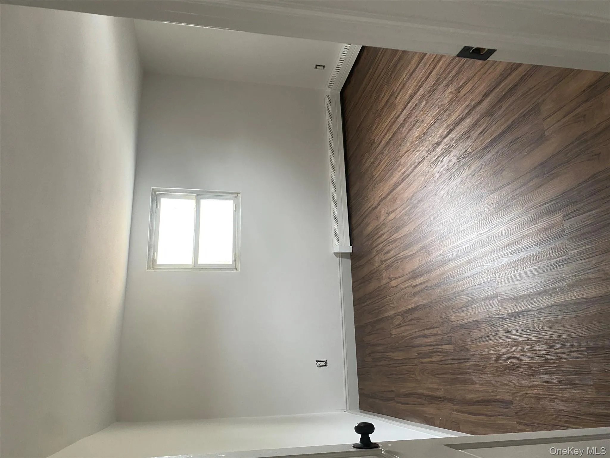 Spare room featuring dark wood-style floors and a baseboard heating unit Spare room featuring dark wood-style floors and a baseboard heating unit