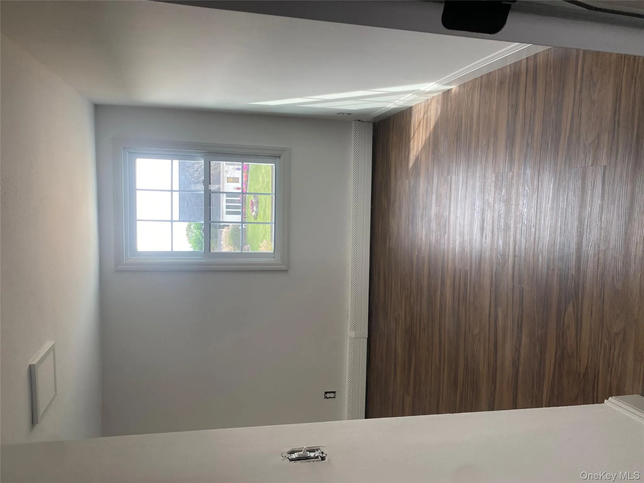 Unfurnished room with dark wood-style flooring and a baseboard radiator Unfurnished room with dark wood-style flooring and a baseboard radiator