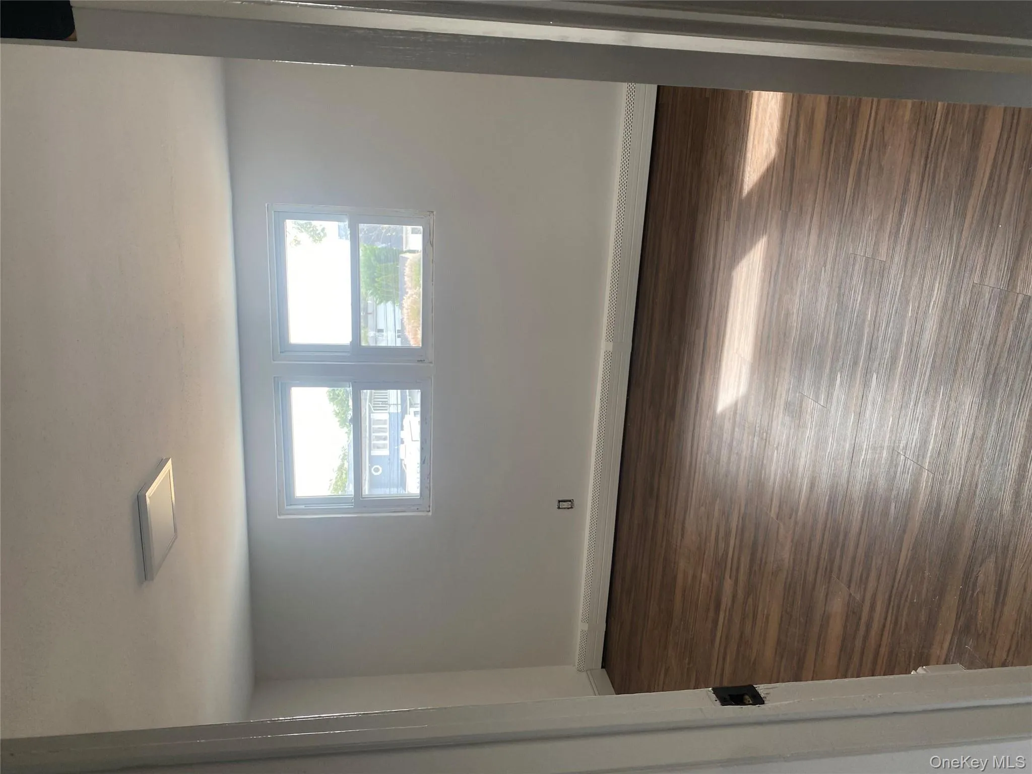 Unfurnished room with baseboard heating and dark wood finished floors Unfurnished room with baseboard heating and dark wood finished floors