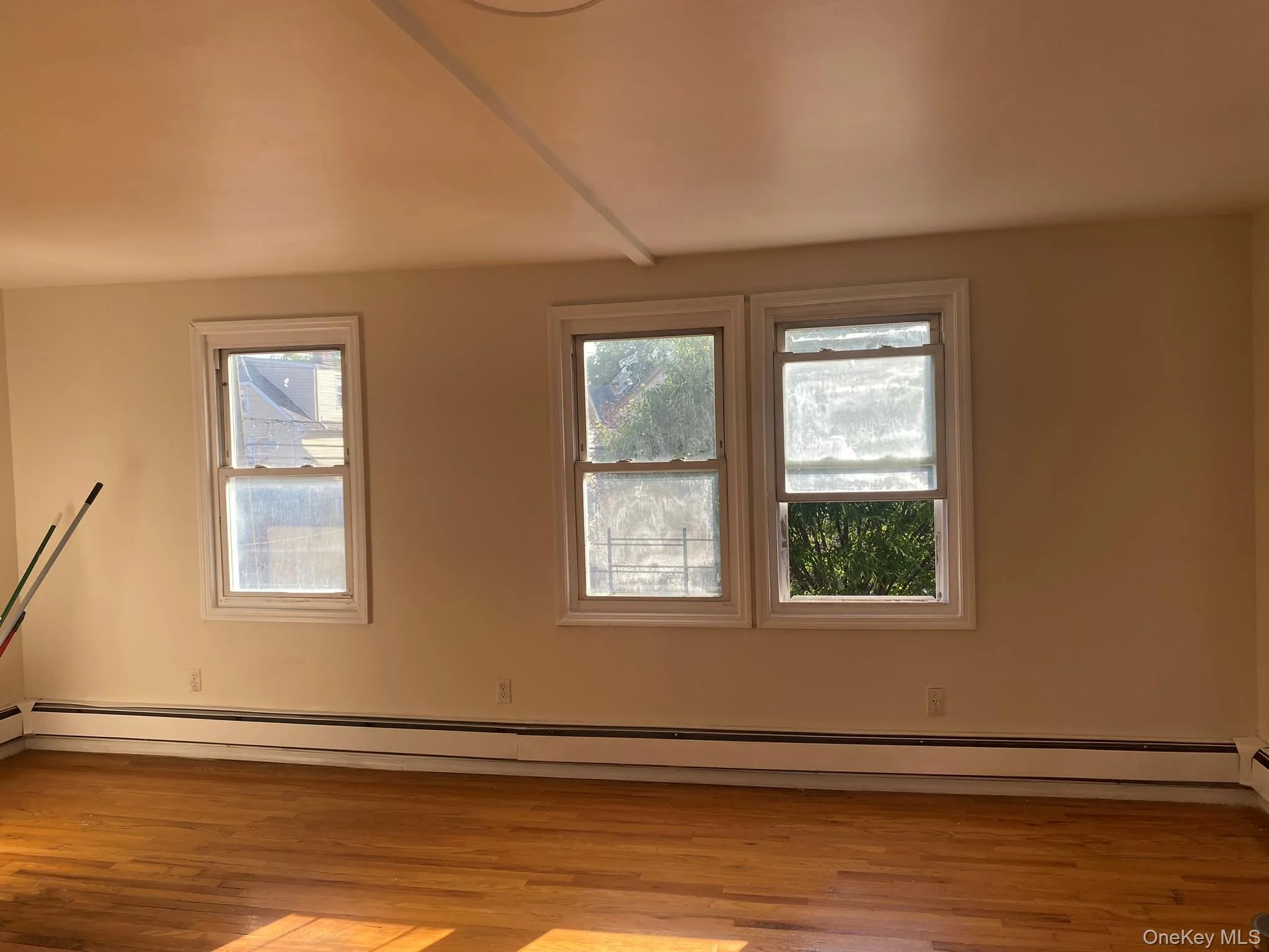 Unfurnished room featuring baseboard heating and light wood finished floors Unfurnished room featuring baseboard heating and light wood finished floors