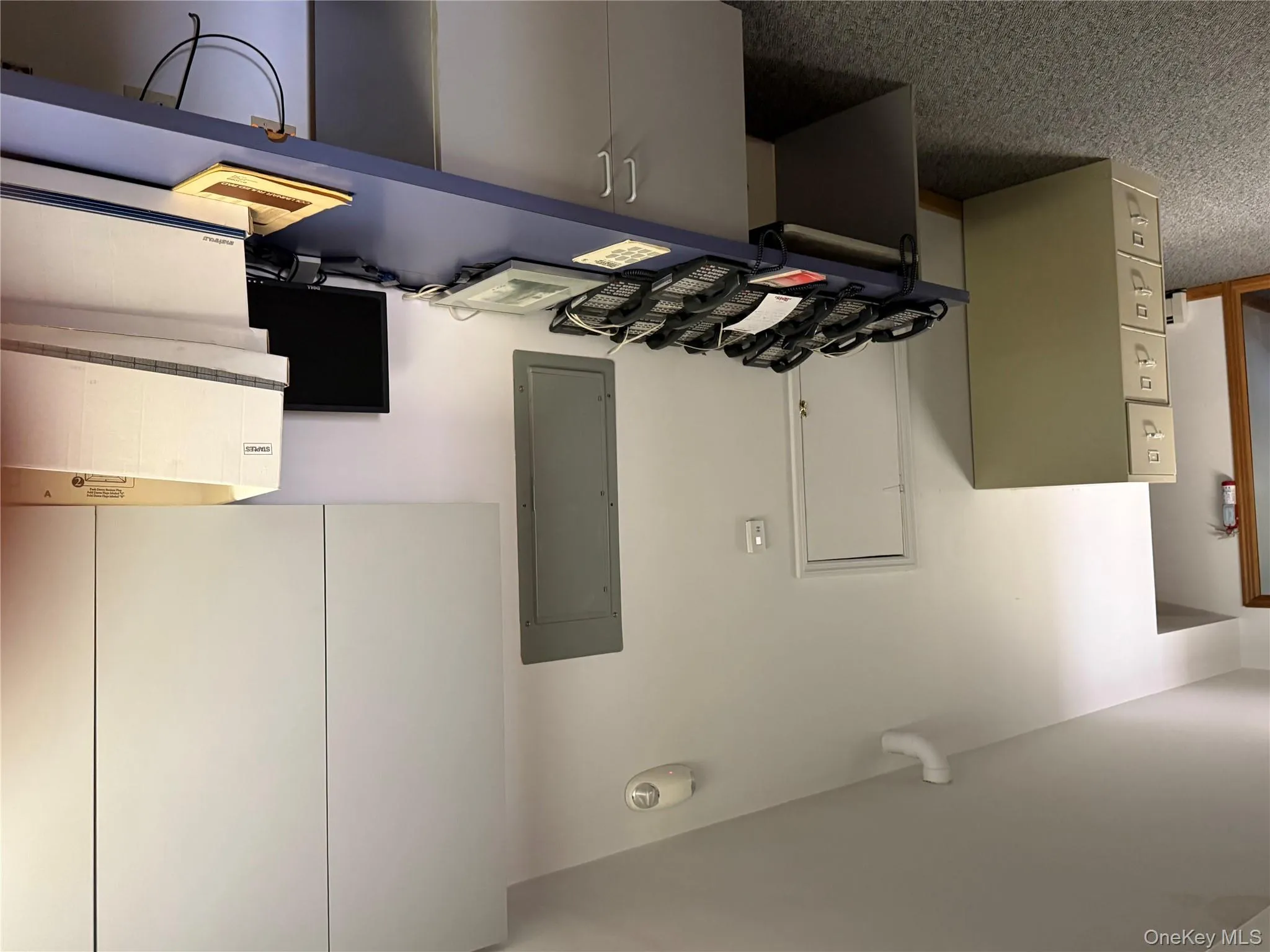 Home office with electric panel, dark carpet, and built in study area Home office with electric panel, dark carpet, and built in study area