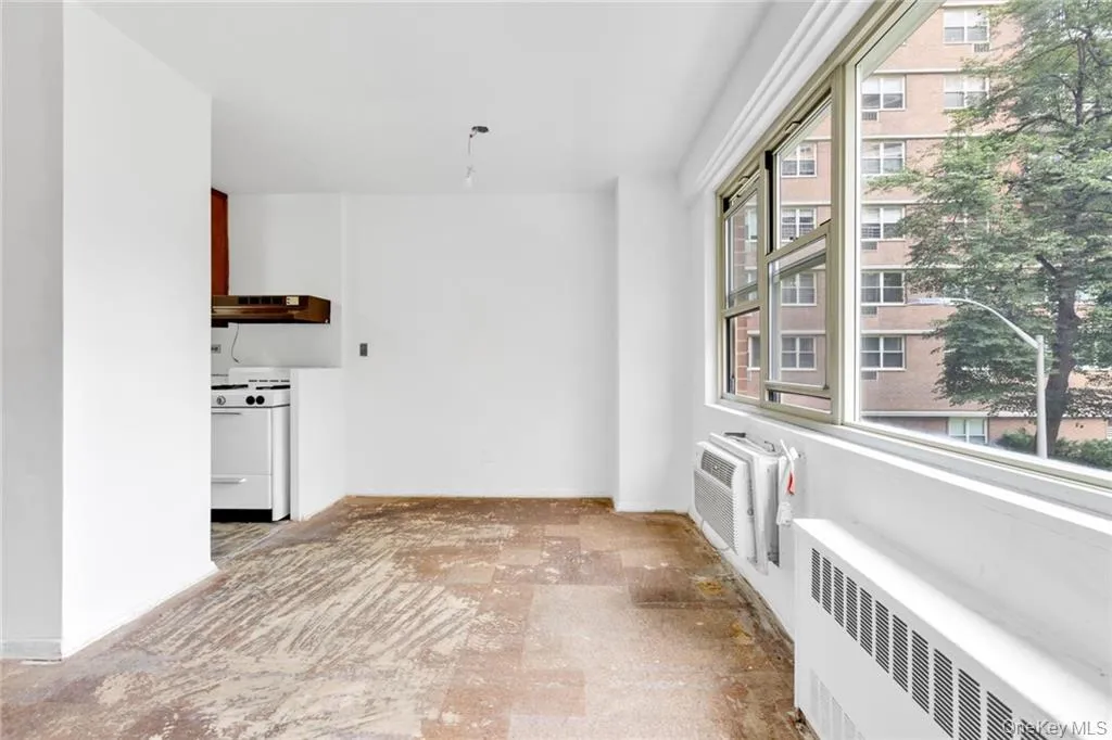Empty room with radiator heating unit and a wall mounted AC Empty room with radiator heating unit and a wall mounted AC