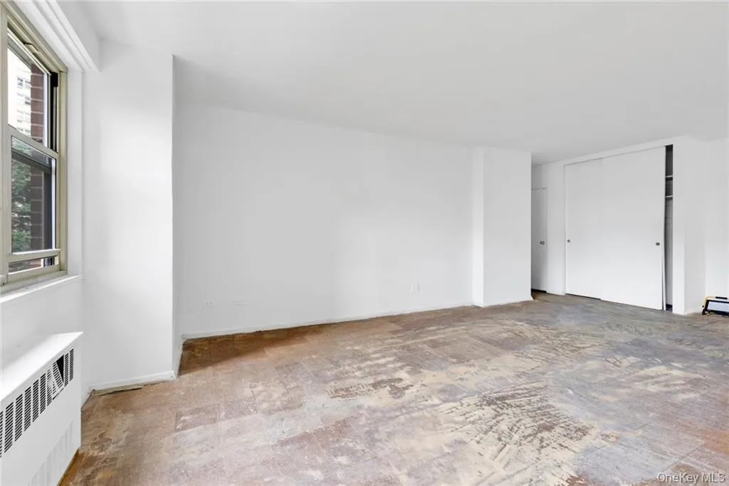 Unfurnished room featuring radiator heating unit and baseboards Unfurnished room featuring radiator heating unit and baseboards