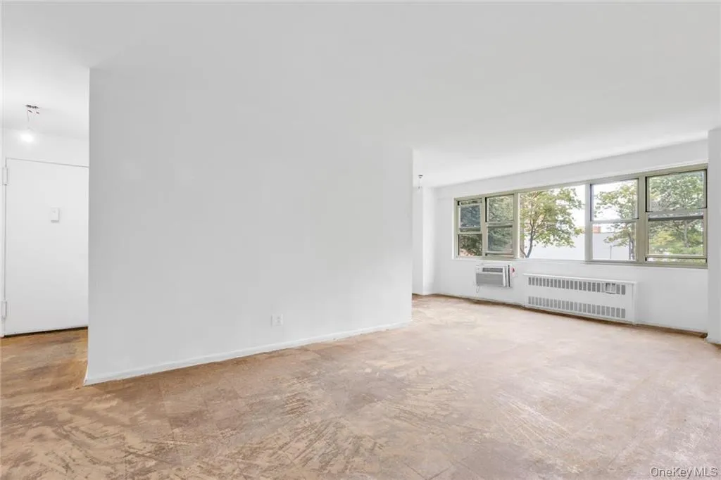 Empty room featuring light colored carpet and radiator Empty room featuring light colored carpet and radiator