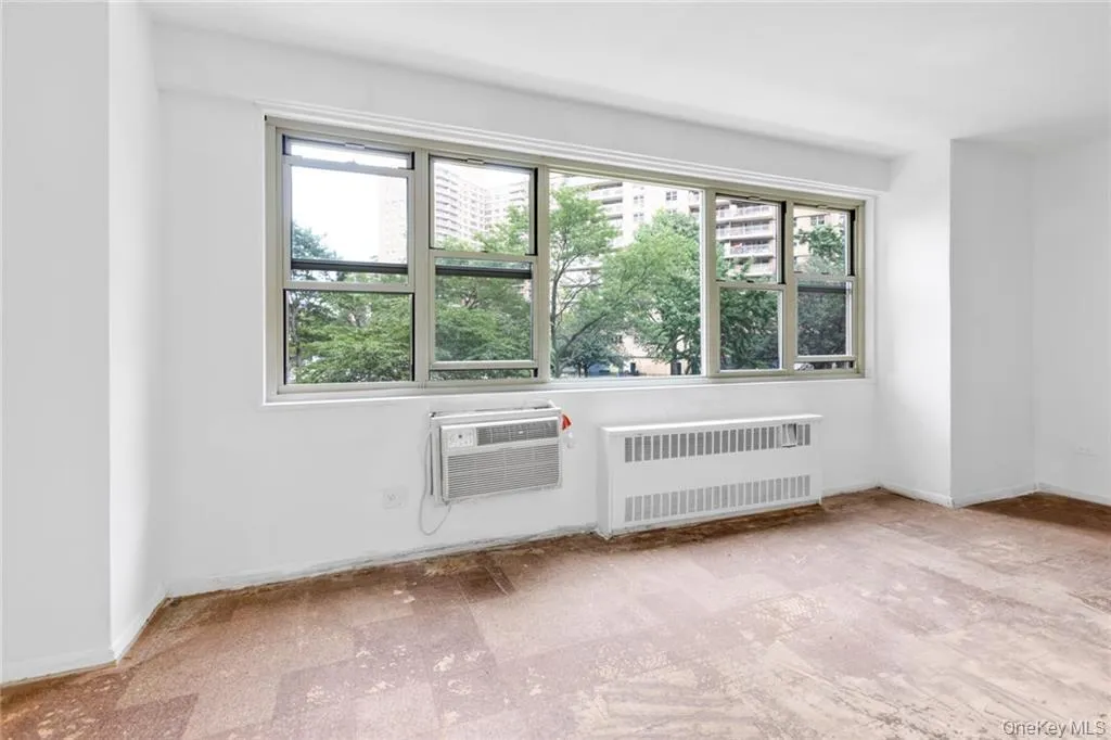 Spare room with radiator heating unit and an AC wall unit Spare room with radiator heating unit and an AC wall unit