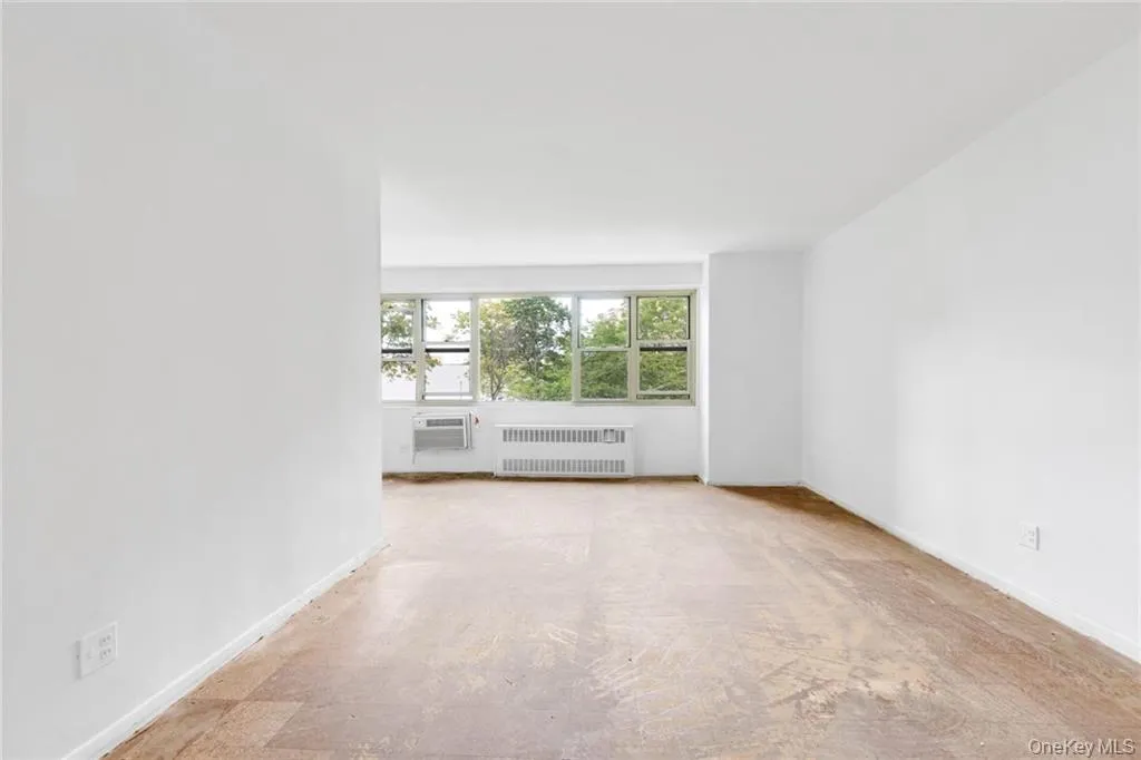 Empty room with radiator heating unit and baseboards Empty room with radiator heating unit and baseboards