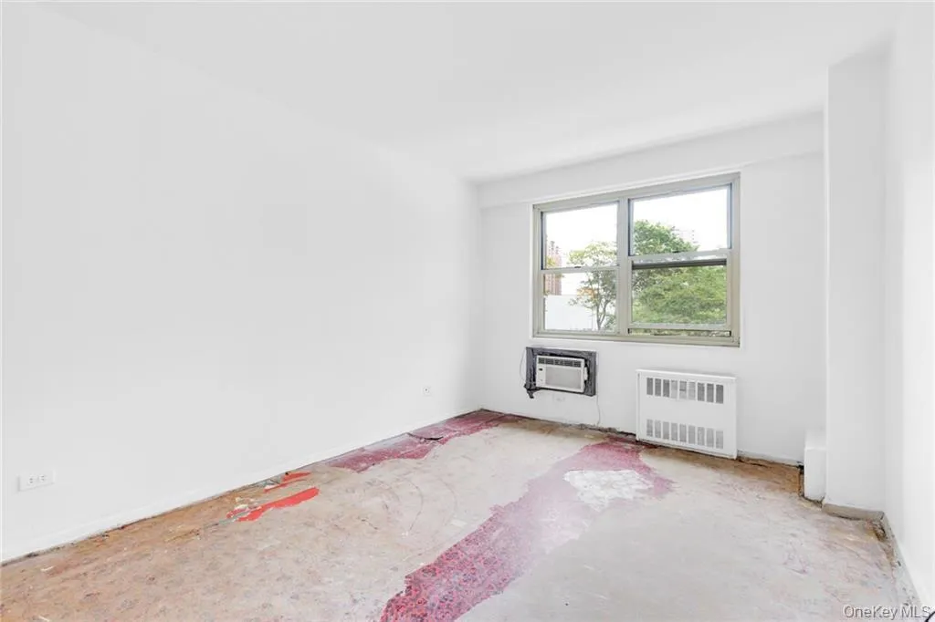 Unfurnished room with radiator and baseboards Unfurnished room with radiator and baseboards