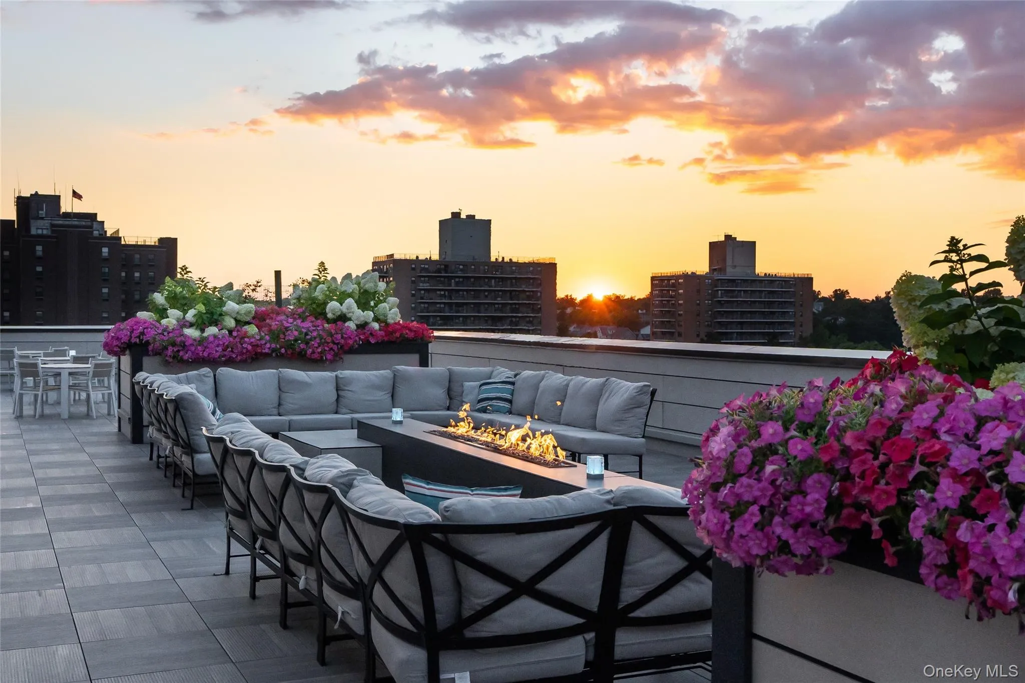 Patio terrace at dusk featuring an outdoor living space with a fire pit, a city view, and a patio area Patio terrace at dusk featuring an outdoor living space with a fire pit, a city view, and a patio area