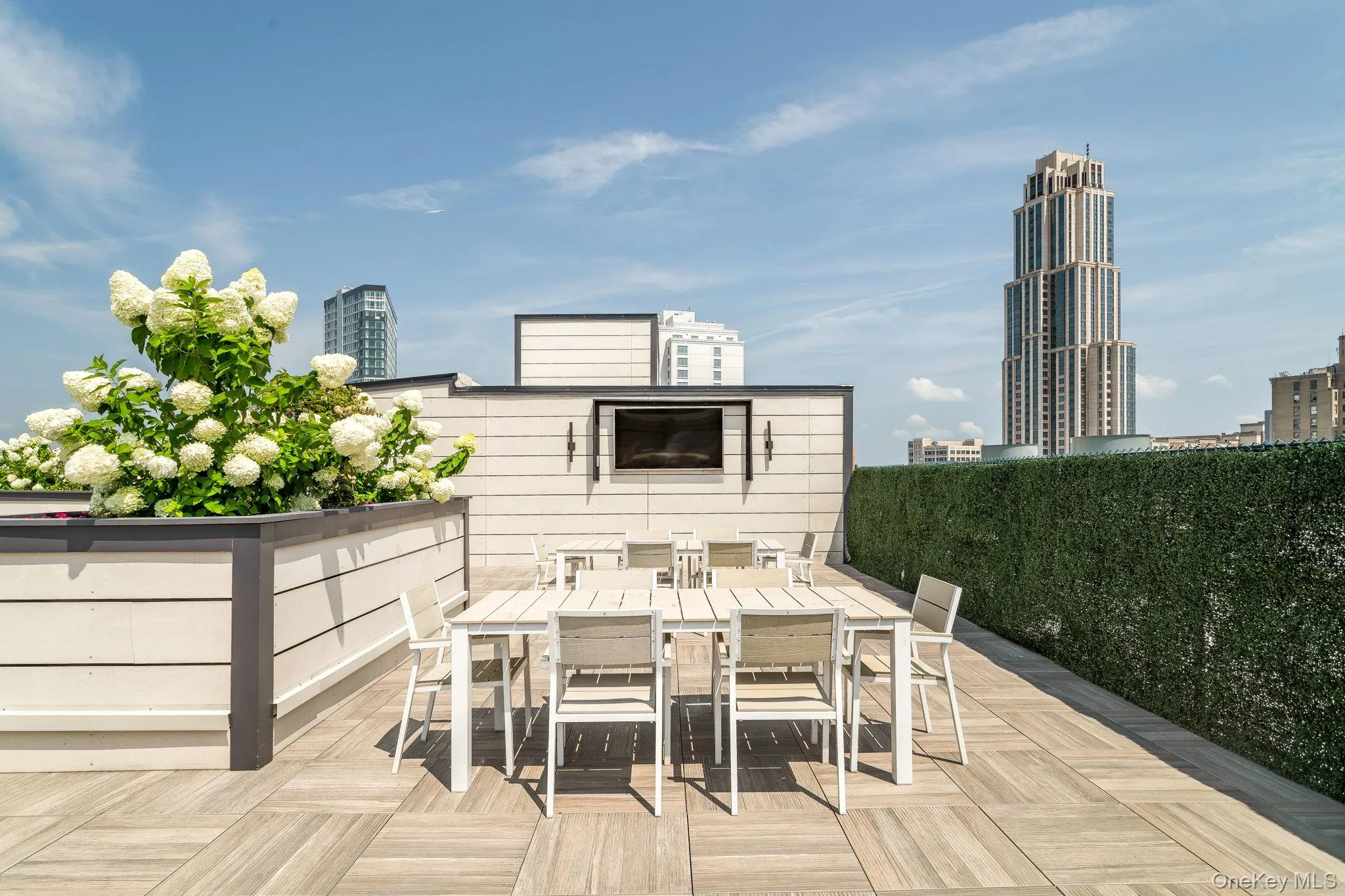 Wooden terrace featuring outdoor dining area and a city view Wooden terrace featuring outdoor dining area and a city view