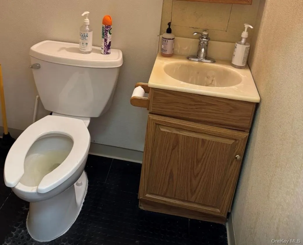 Half bath featuring a textured wall and vanity Half bath featuring a textured wall and vanity