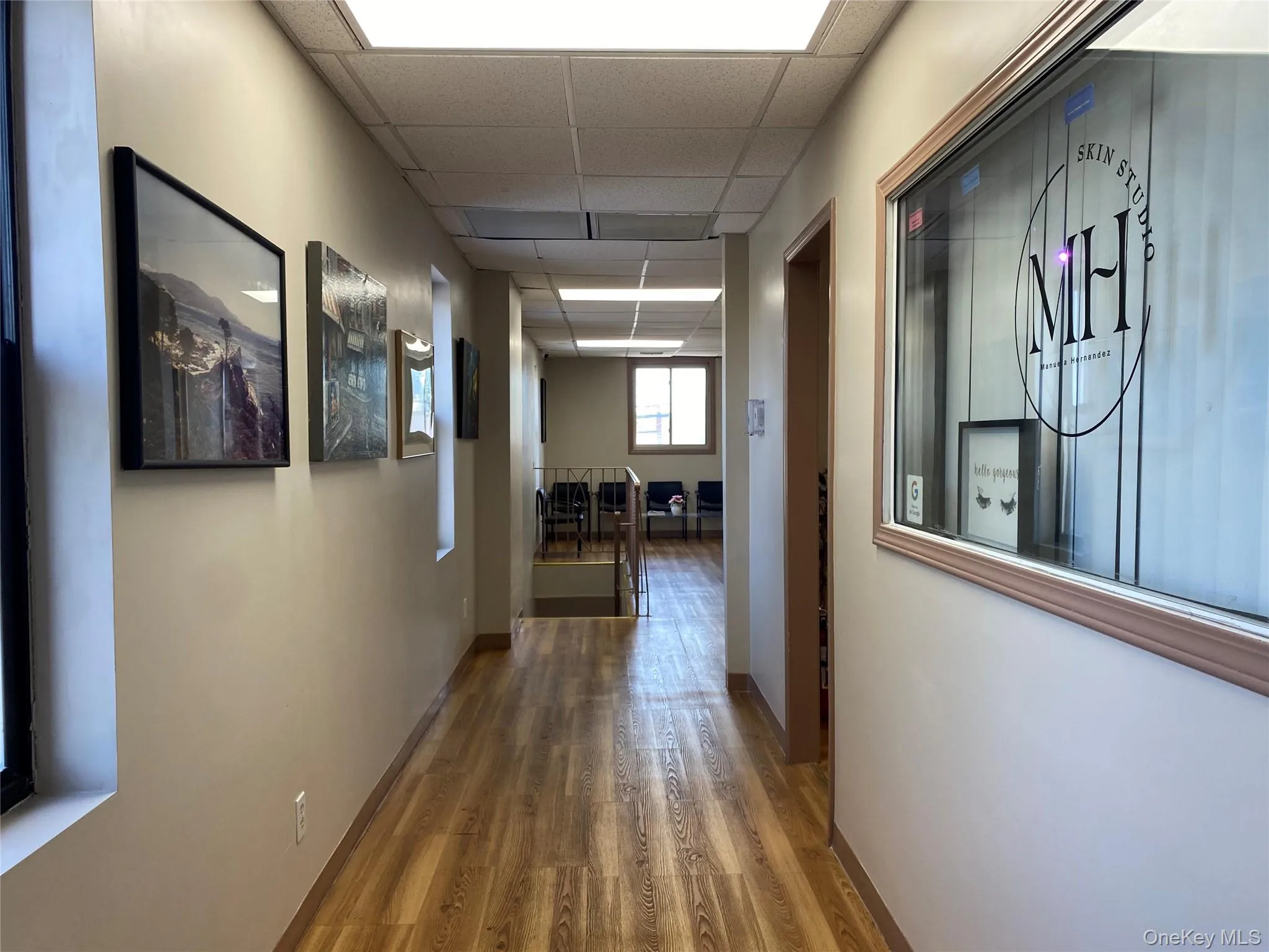 Hall with a drop ceiling and wood finished floors Hall with a drop ceiling and wood finished floors