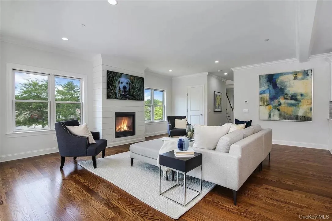 Living room featuring beamed ceiling, ornamental molding, dark hardwood / wood flooring, and a fireplace Living room featuring beamed ceiling, ornamental molding, dark hardwood / wood flooring, and a fireplace