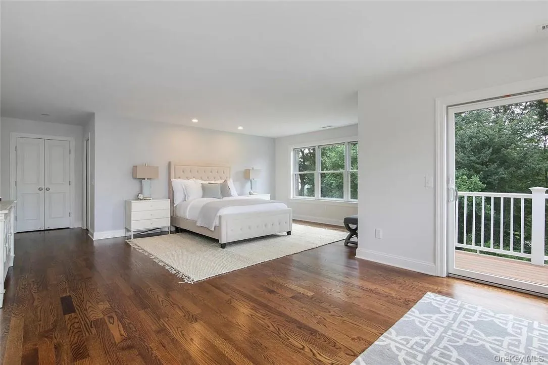Furnished bedroom featuring access to outside and hardwood floors Furnished bedroom featuring access to outside and hardwood floors