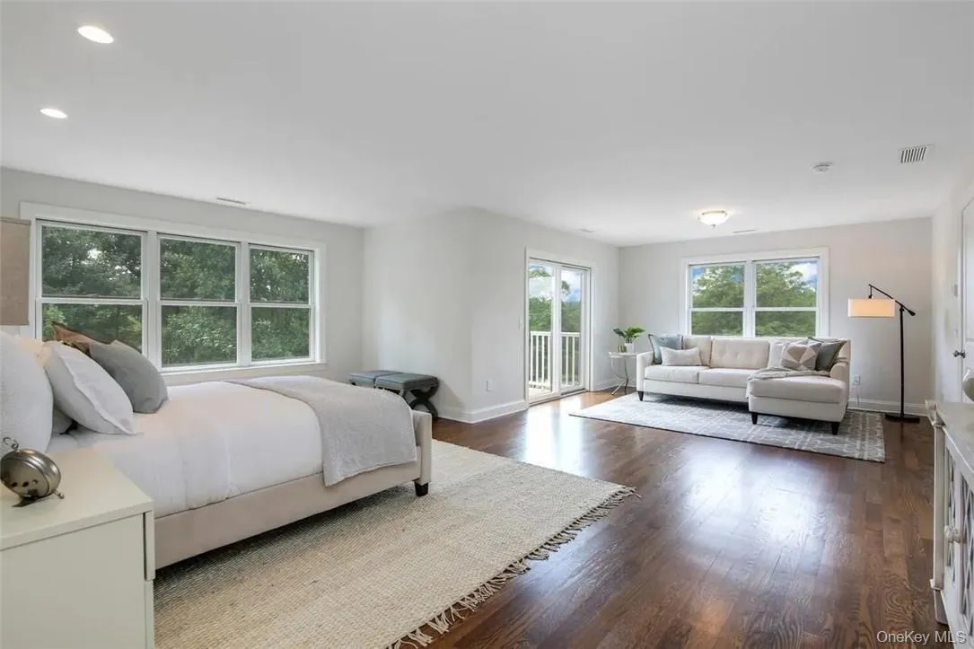 Bedroom with dark hardwood / wood-style floors and access to exterior Bedroom with dark hardwood / wood-style floors and access to exterior