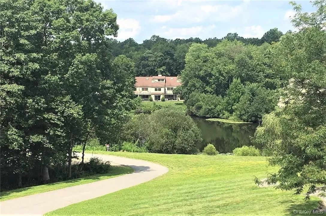 View of property's community featuring a lawn and a water view View of property's community featuring a lawn and a water view