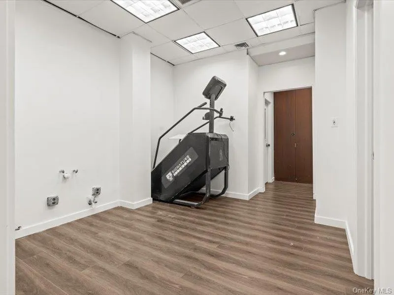 Workout area featuring a drop ceiling and wood finished floors Workout area featuring a drop ceiling and wood finished floors