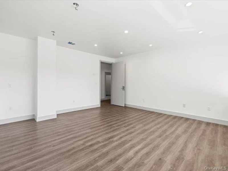 Empty room with light wood-style floors and recessed lighting Empty room with light wood-style floors and recessed lighting