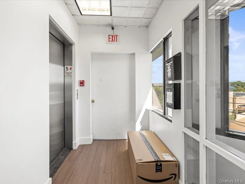 Corridor featuring a paneled ceiling, dark wood finished floors, and elevator Corridor featuring a paneled ceiling, dark wood finished floors, and elevator