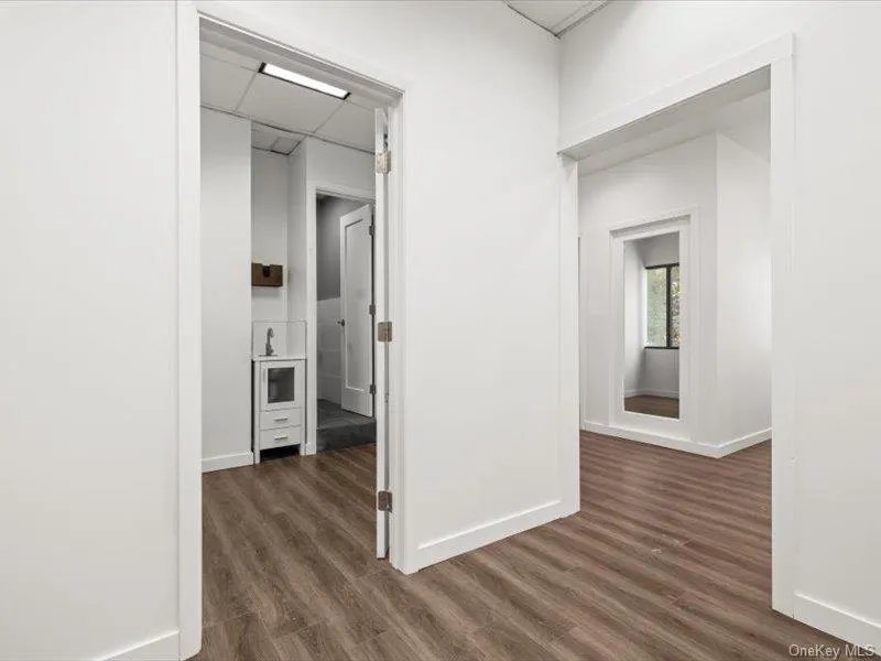 Hall featuring dark wood-type flooring and a paneled ceiling Hall featuring dark wood-type flooring and a paneled ceiling