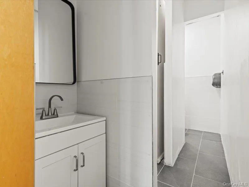 Bathroom featuring vanity and dark tile patterned floors Bathroom featuring vanity and dark tile patterned floors