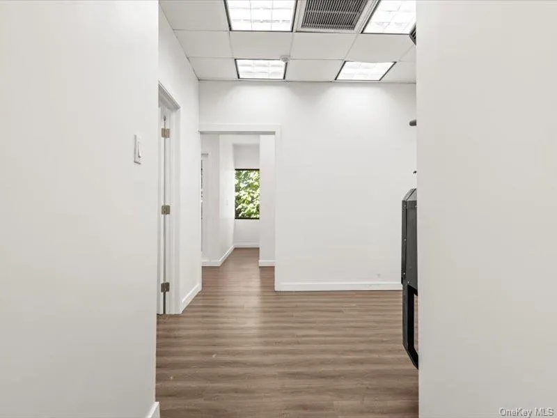 Hall with a drop ceiling and dark wood-style floors Hall with a drop ceiling and dark wood-style floors