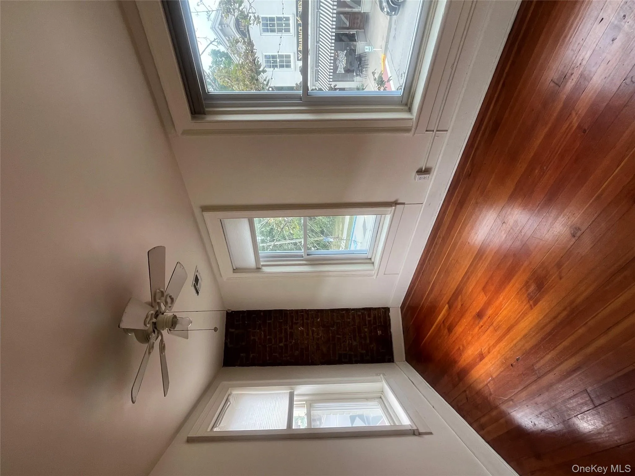Unfurnished room with hardwood / wood-style flooring, plenty of natural light, and a ceiling fan Unfurnished room with hardwood / wood-style flooring, plenty of natural light, and a ceiling fan