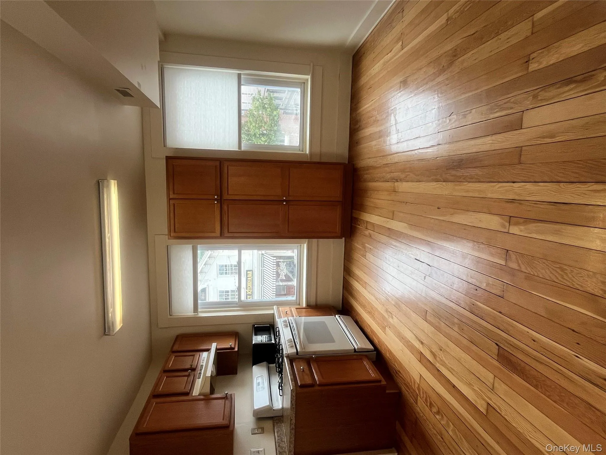 Kitchen featuring brown cabinetry, stove, and light wood-style flooring Kitchen featuring brown cabinetry, stove, and light wood-style flooring