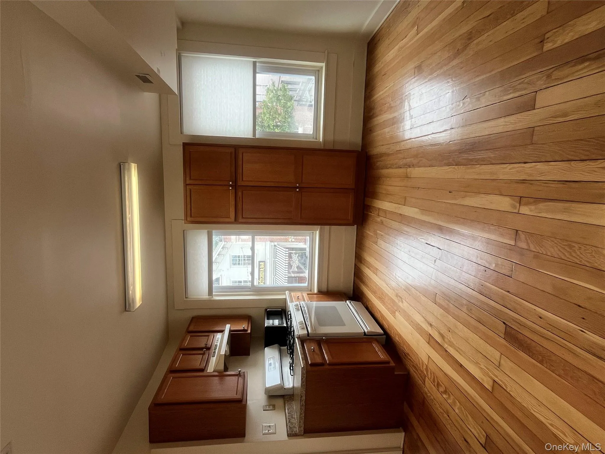 Kitchen featuring brown cabinets, stove, and light wood-style flooring Kitchen featuring brown cabinets, stove, and light wood-style flooring