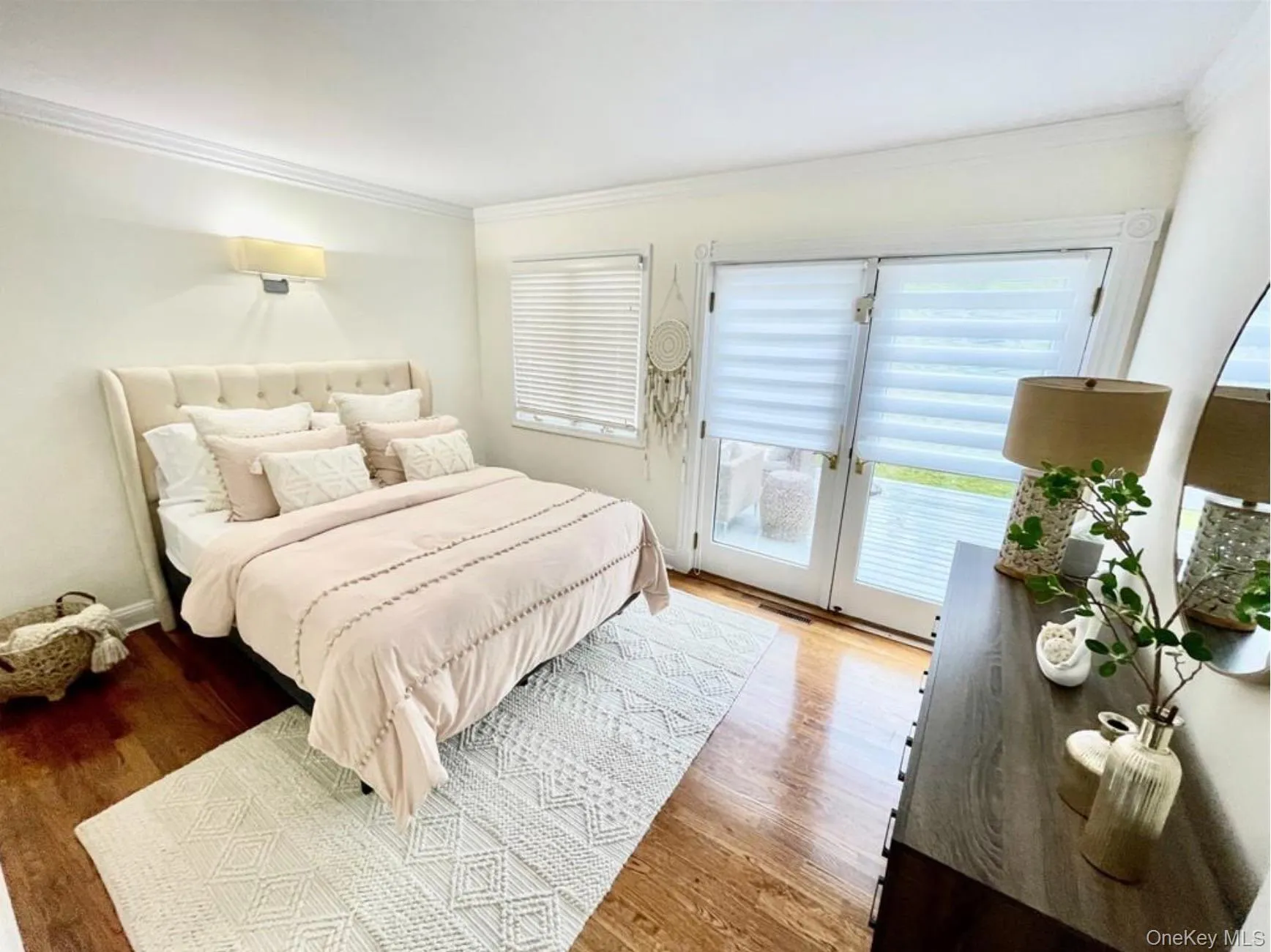 Bedroom with access to outside, ornamental molding, and wood finished floors Bedroom with access to outside, ornamental molding, and wood finished floors
