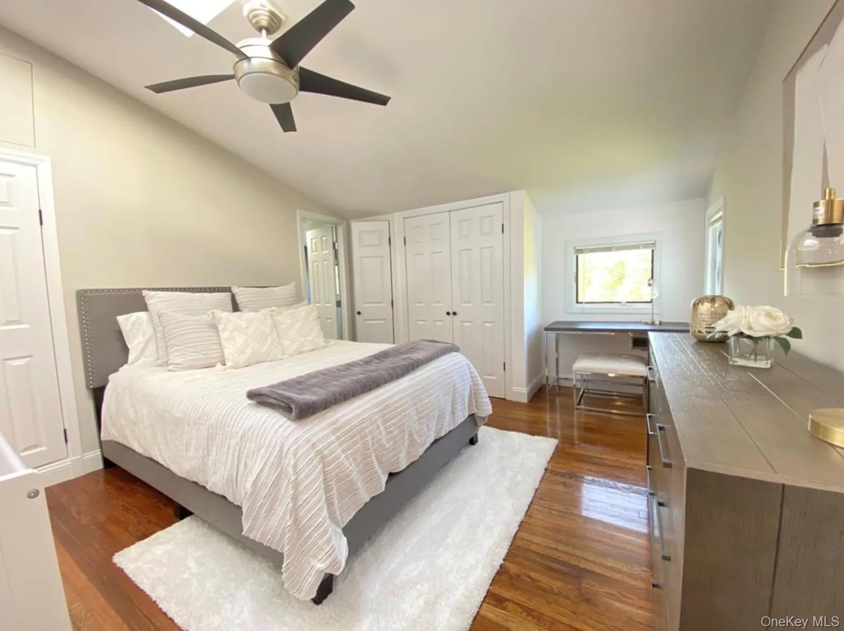 Bedroom featuring dark wood finished floors, lofted ceiling, and ceiling fan Bedroom featuring dark wood finished floors, lofted ceiling, and ceiling fan