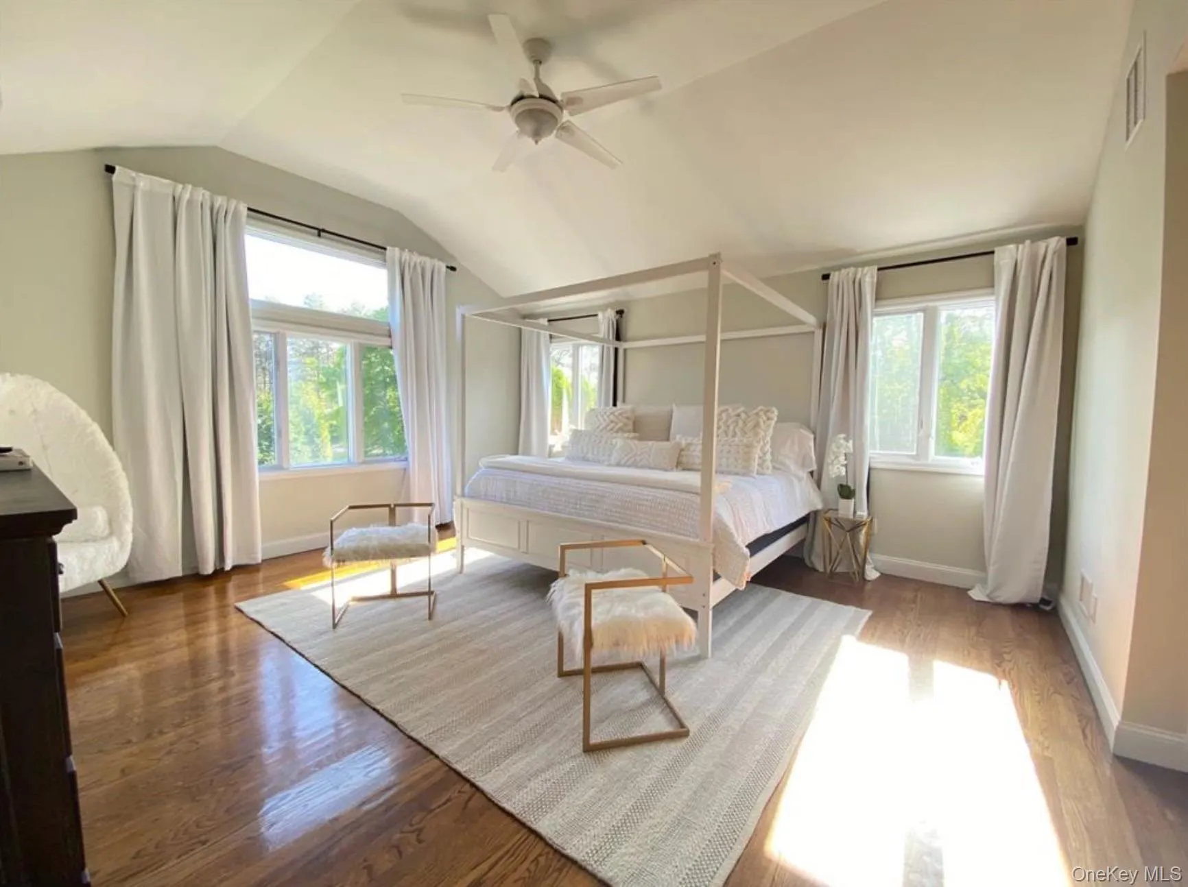 Bedroom featuring wood finished floors, vaulted ceiling, and a ceiling fan Bedroom featuring wood finished floors, vaulted ceiling, and a ceiling fan