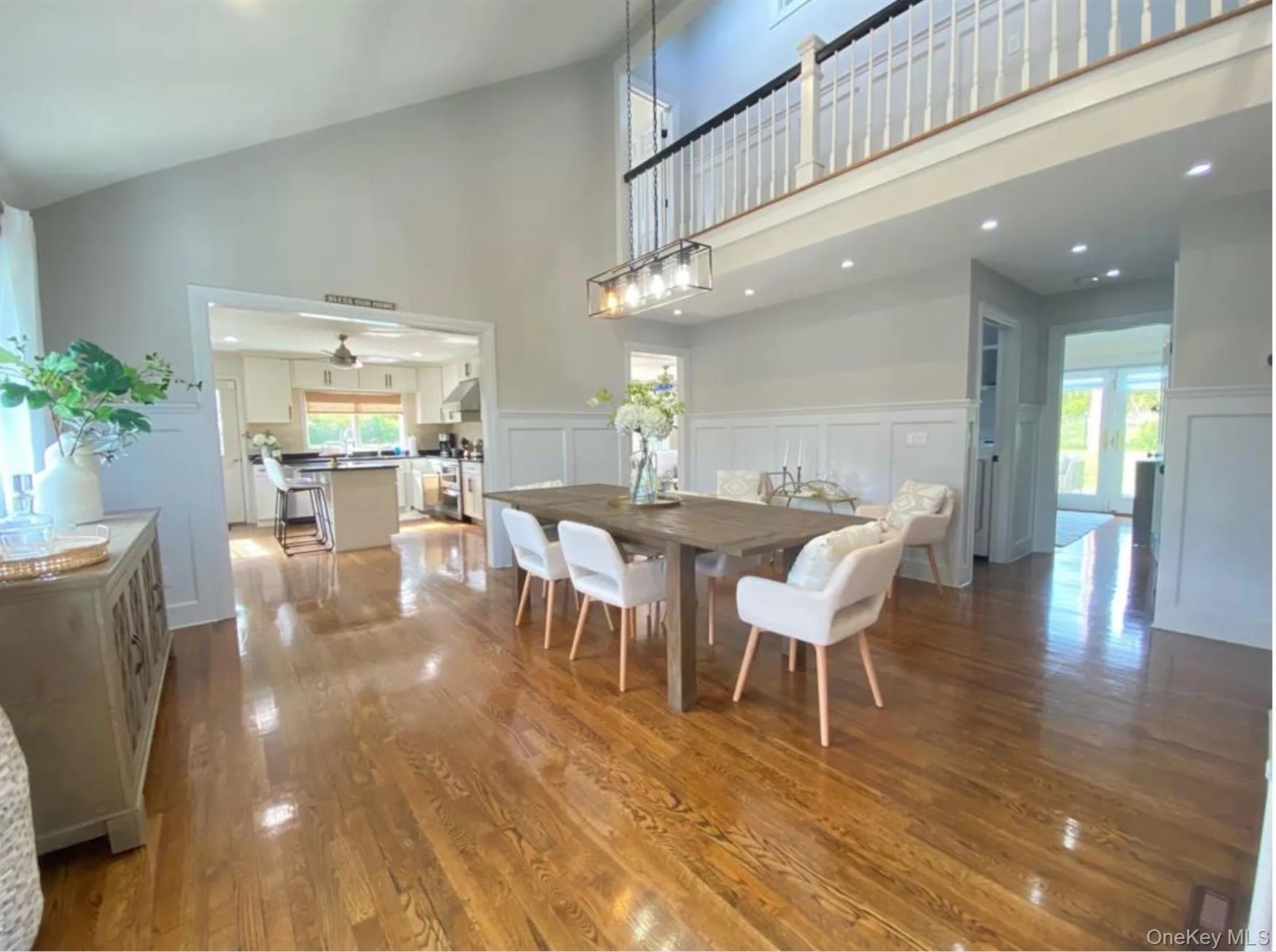 Dining room with wood finished floors, recessed lighting, a decorative wall, high vaulted ceiling, and ceiling fan Dining room with wood finished floors, recessed lighting, a decorative wall, high vaulted ceiling, and ceiling fan
