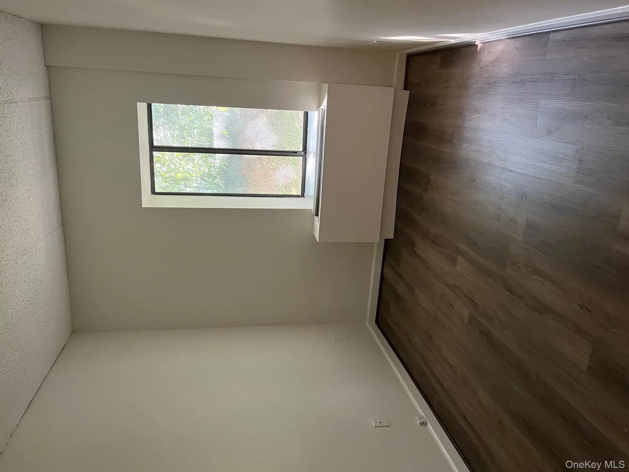 Empty room with dark wood-type flooring and baseboards Empty room with dark wood-type flooring and baseboards
