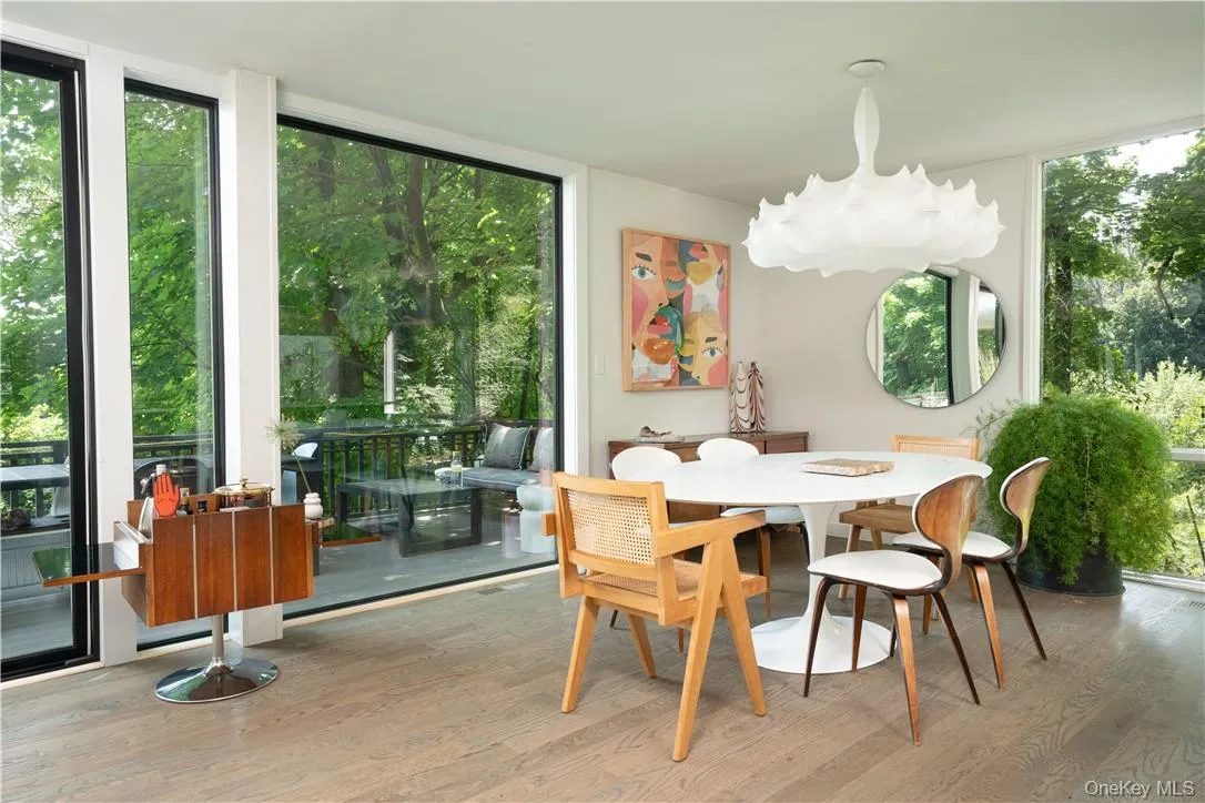 Dining area with floor to ceiling windows and light hardwood / wood-style flooring Dining area with floor to ceiling windows and light hardwood / wood-style flooring