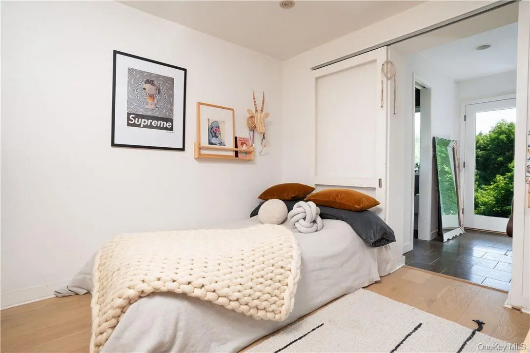 Bedroom with access to exterior, light hardwood / wood-style flooring, and a closet Bedroom with access to exterior, light hardwood / wood-style flooring, and a closet