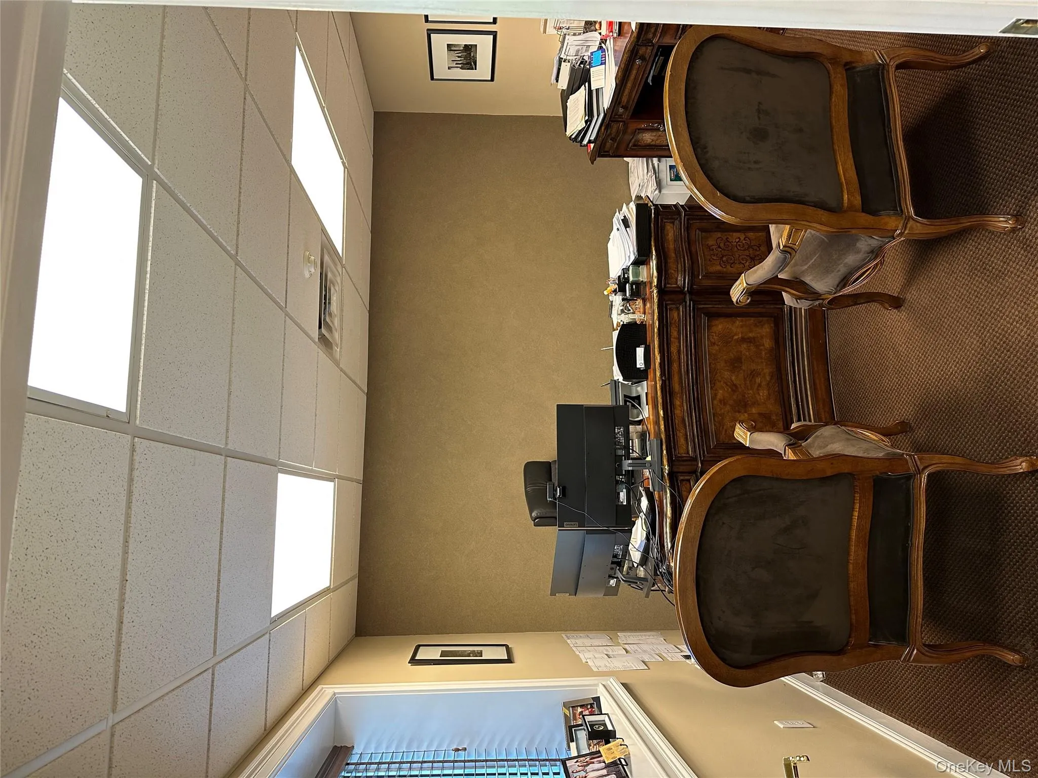 Carpeted office space featuring a drop ceiling and baseboards Carpeted office space featuring a drop ceiling and baseboards