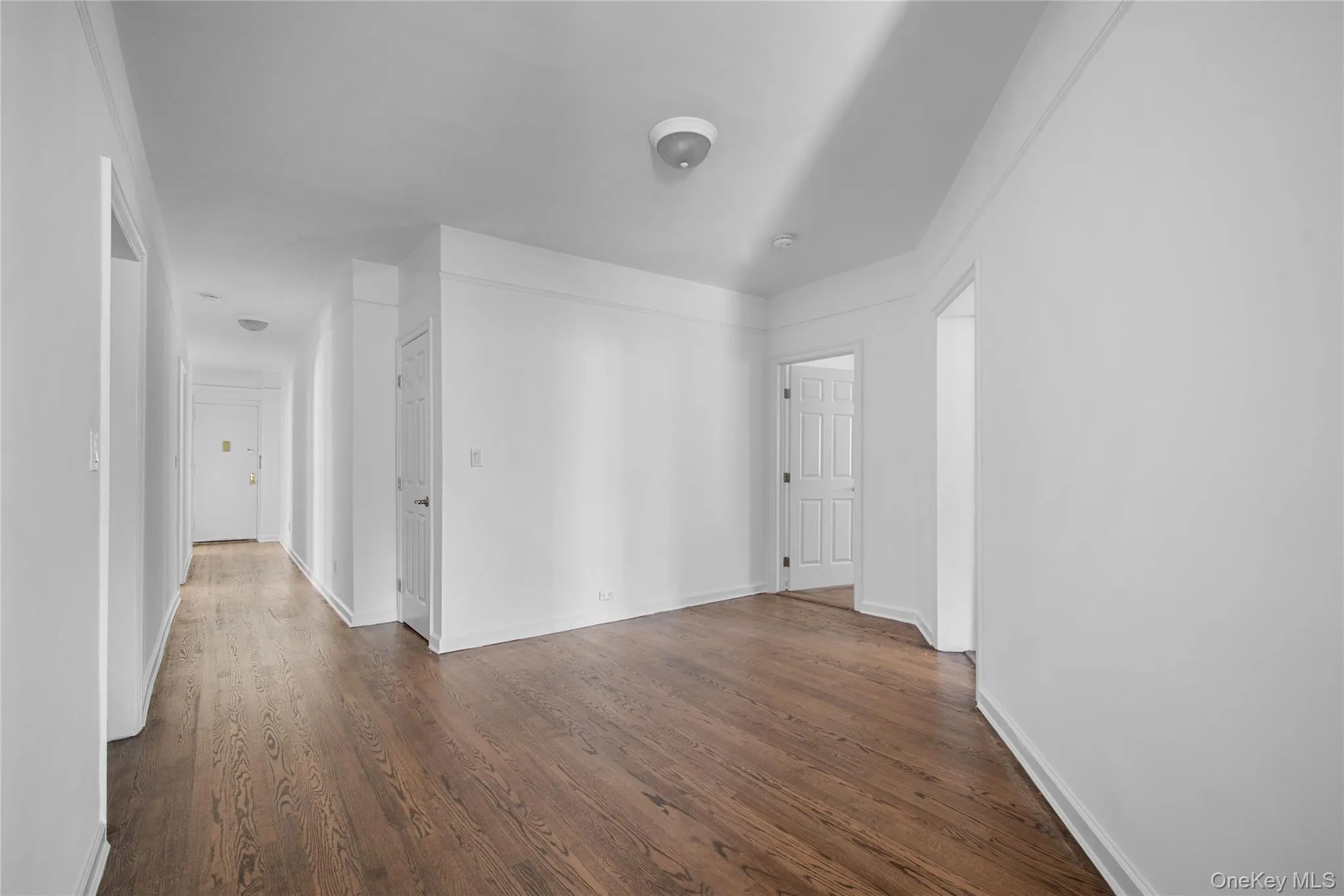 Spare room featuring dark wood-style floors and baseboards Spare room featuring dark wood-style floors and baseboards