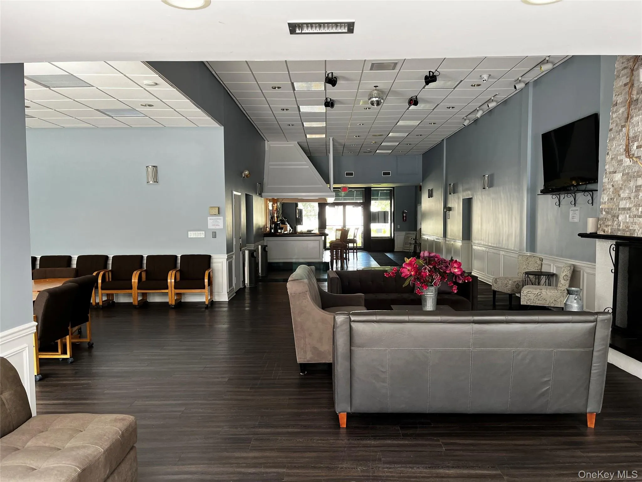 Community lobby with a wainscoted wall, a decorative wall, and a paneled ceiling Community lobby with a wainscoted wall, a decorative wall, and a paneled ceiling