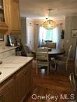 Kitchen featuring light countertops, brown cabinets, and dark wood-style flooring Kitchen featuring light countertops, brown cabinets, and dark wood-style flooring