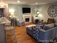 Living room featuring a fireplace, wood finished floors, and recessed lighting Living room featuring a fireplace, wood finished floors, and recessed lighting