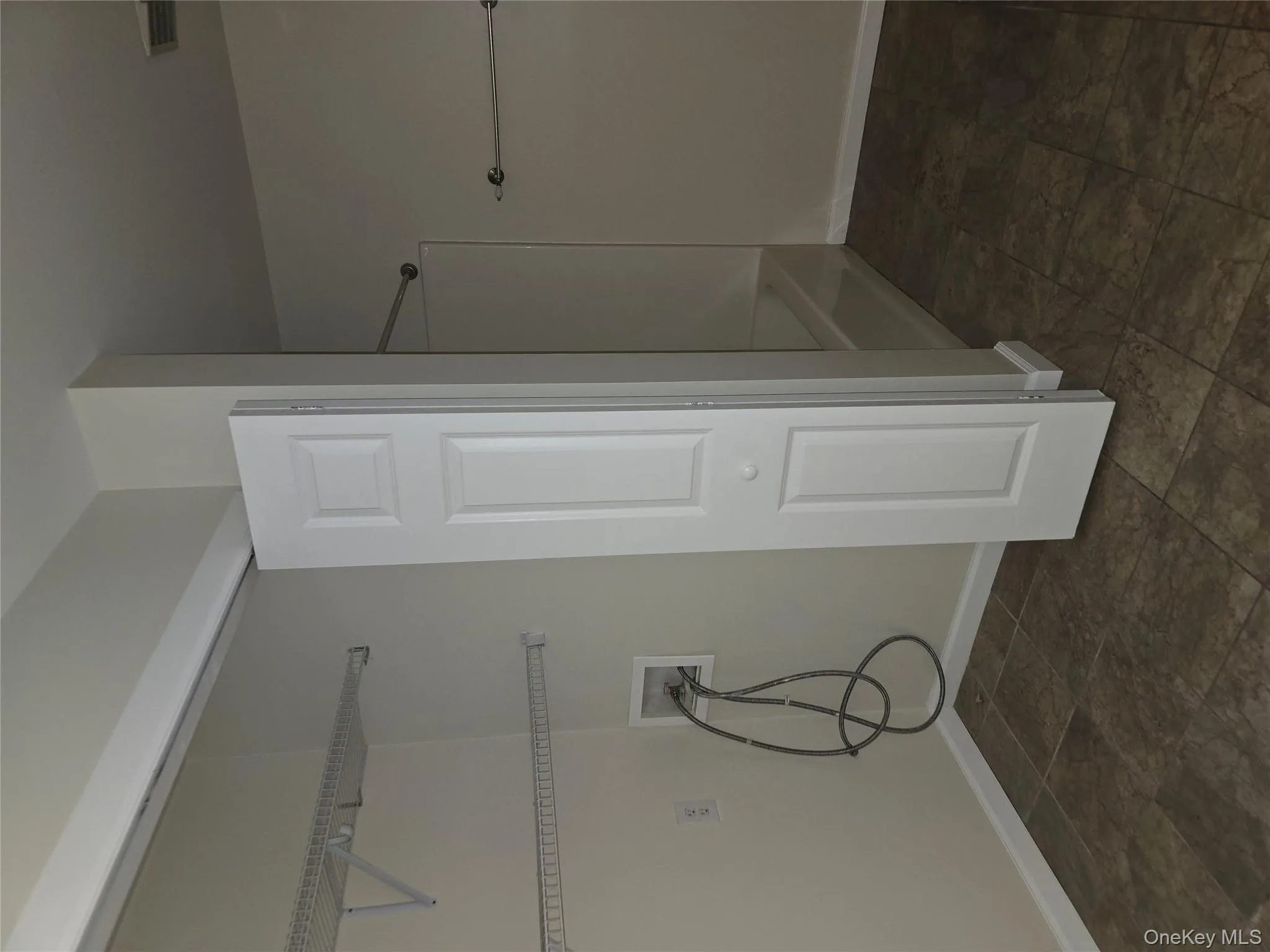 Bathroom with  shower combination, a closet, and dark stone finish floors Bathroom with  shower combination, a closet, and dark stone finish floors