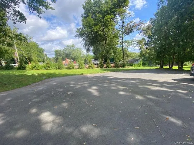 View of asphalt road featuring view of scattered trees View of asphalt road featuring view of scattered trees