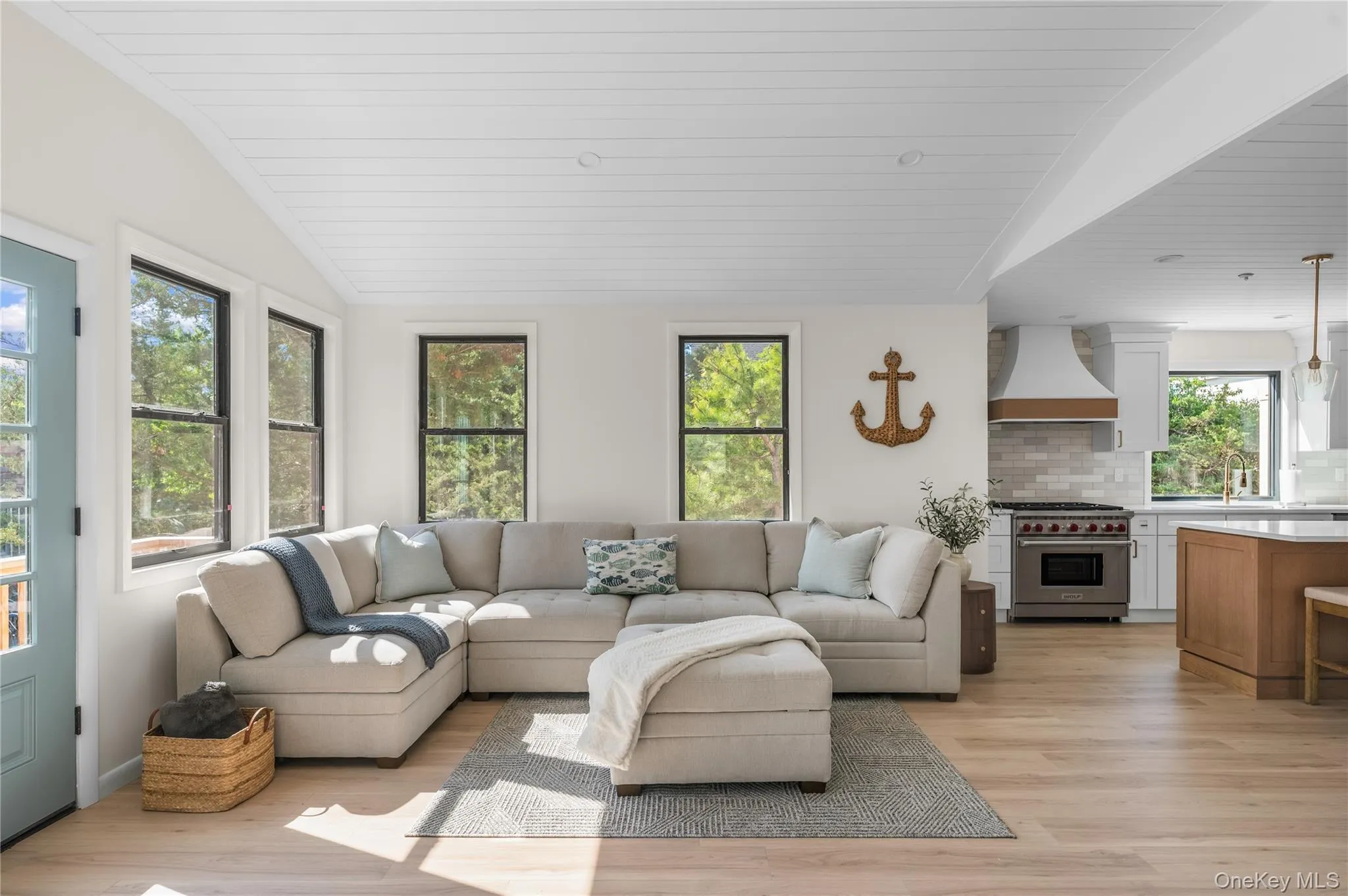 Living room featuring lofted ceiling and light wood-style floors Living room featuring lofted ceiling and light wood-style floors